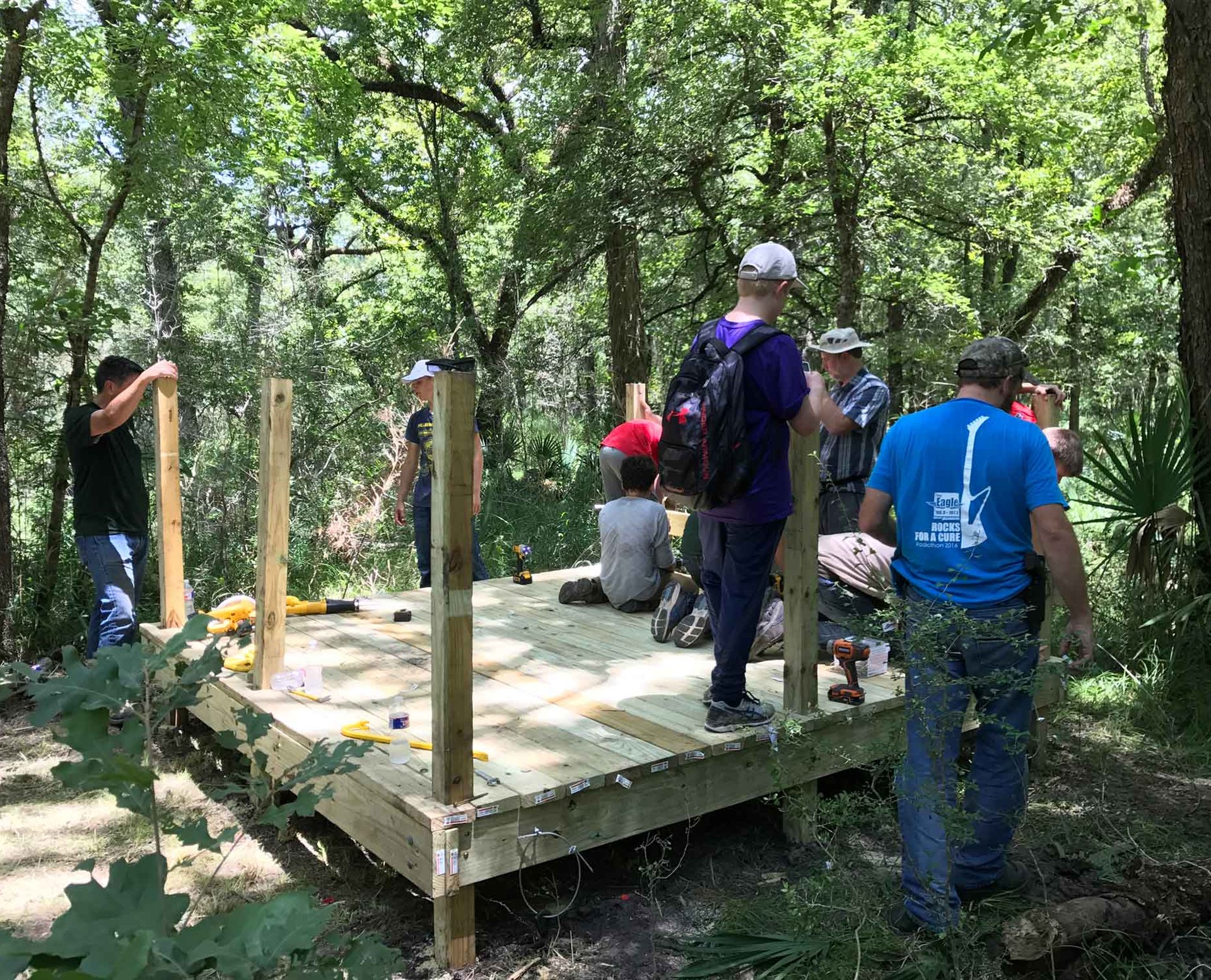 People building a wooden platform in forest